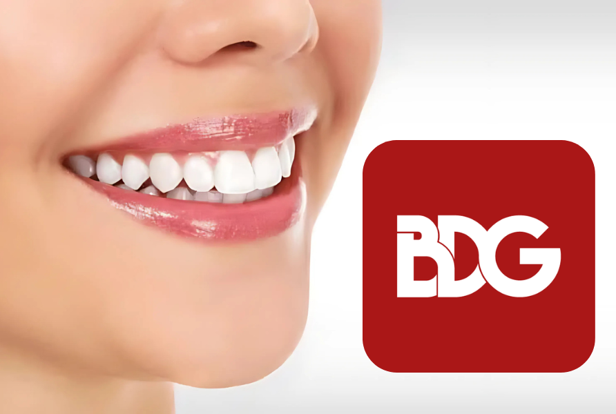 person smiling with a youthful smile and a red and white BDG Logo to the right of the face
