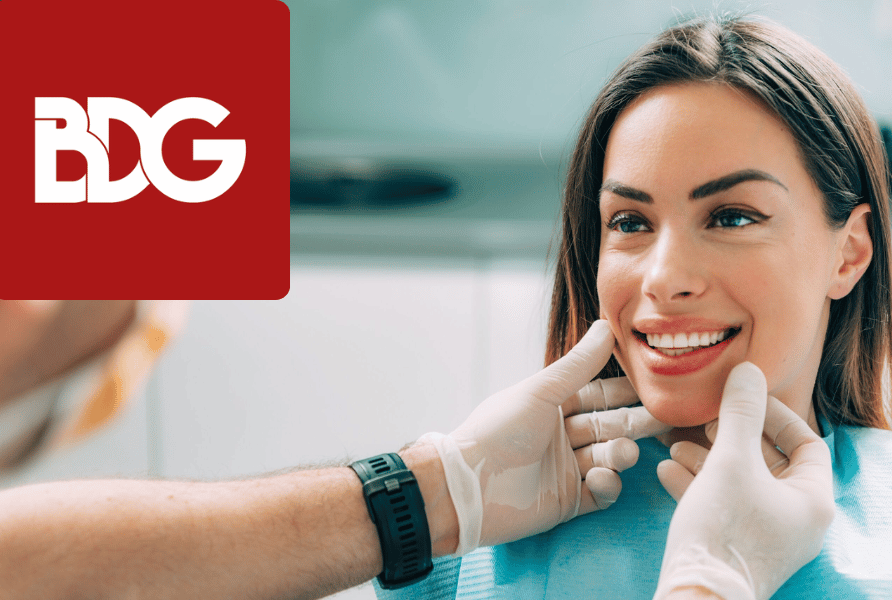 Patient during a cosmetic dentistry consultation being examined by the dentist with red BDG Logo in the top left corner